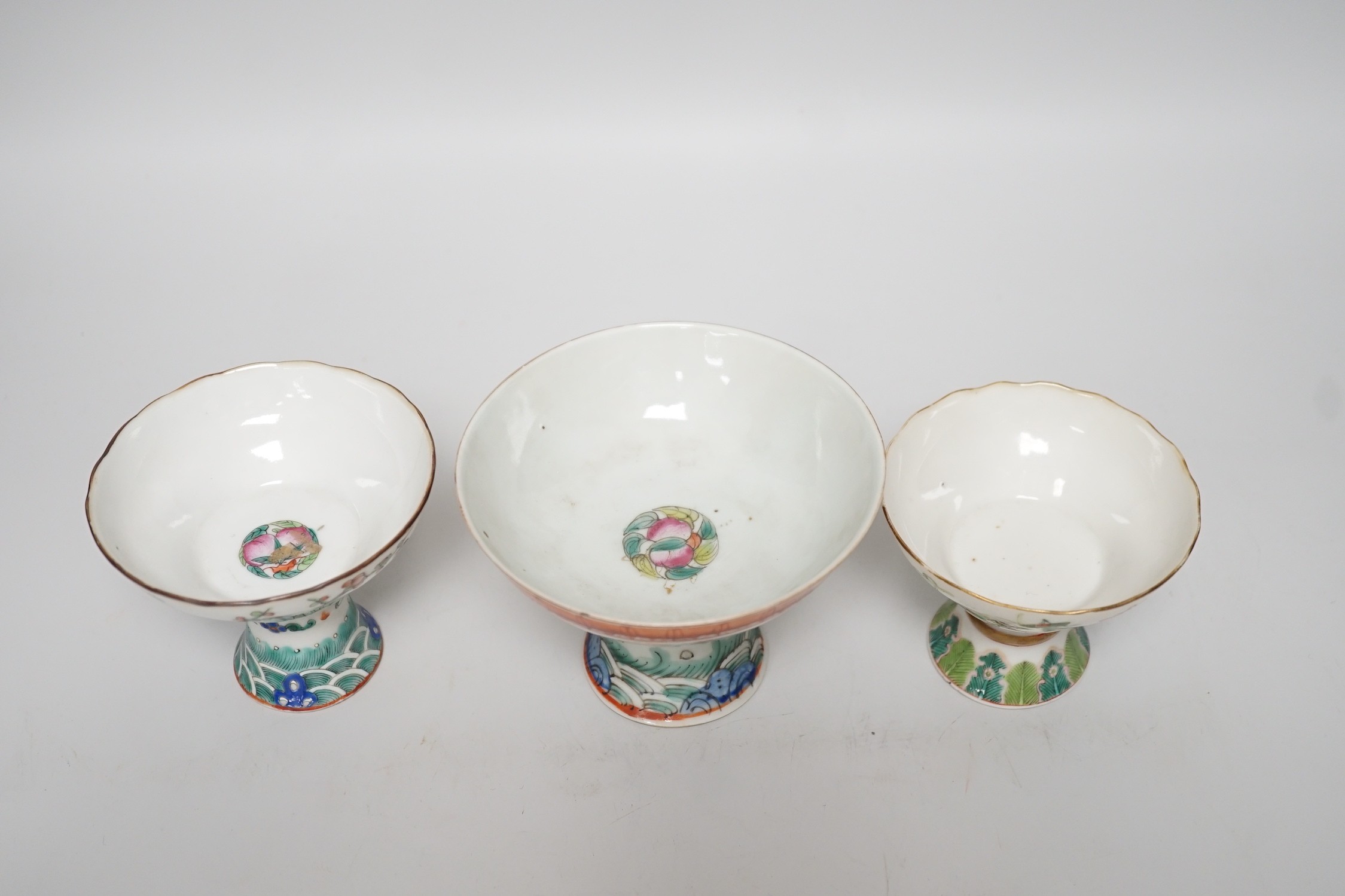Three 19th century Chinese stem cups, painted with insects, flowers, bats and peaches, largest 9cm